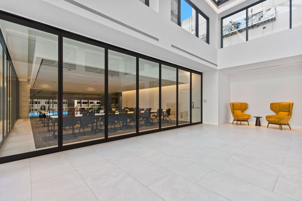 Modern commercial lobby featuring large glass windows, stylish furniture, and a bright, open space.