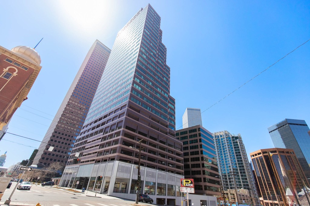 Exterior view of modern commercial skyscrapers in an urban setting under clear blue sky.