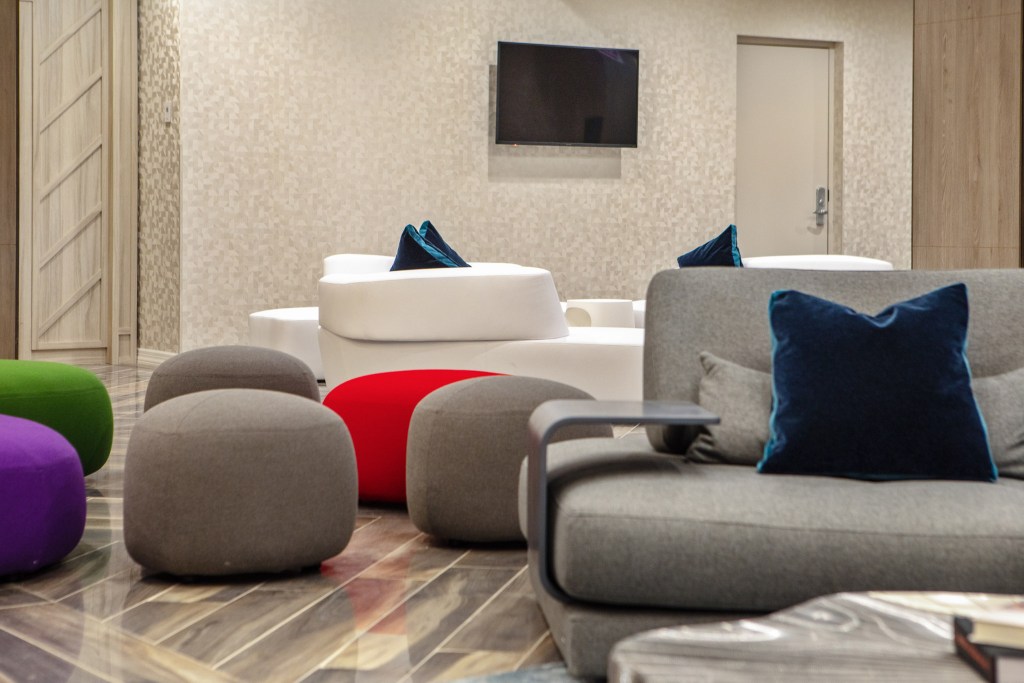 Modern lounge area featuring colorful poufs and contemporary seating arrangements.