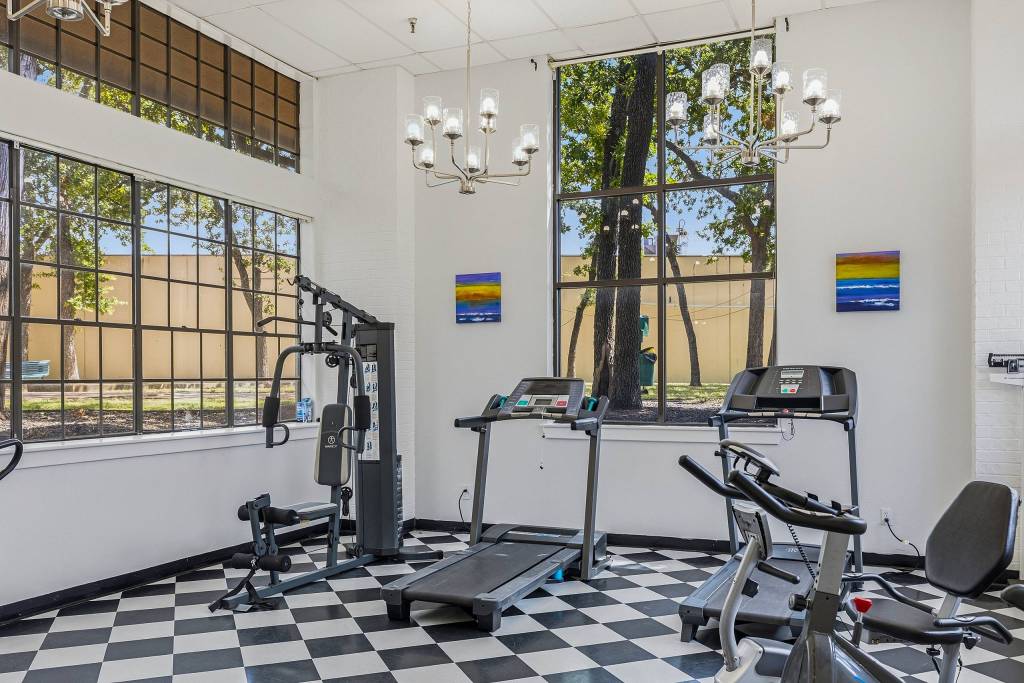 Fitness room with treadmills, home gym and chandeliers at Serenity at Briarcrest 55+ community