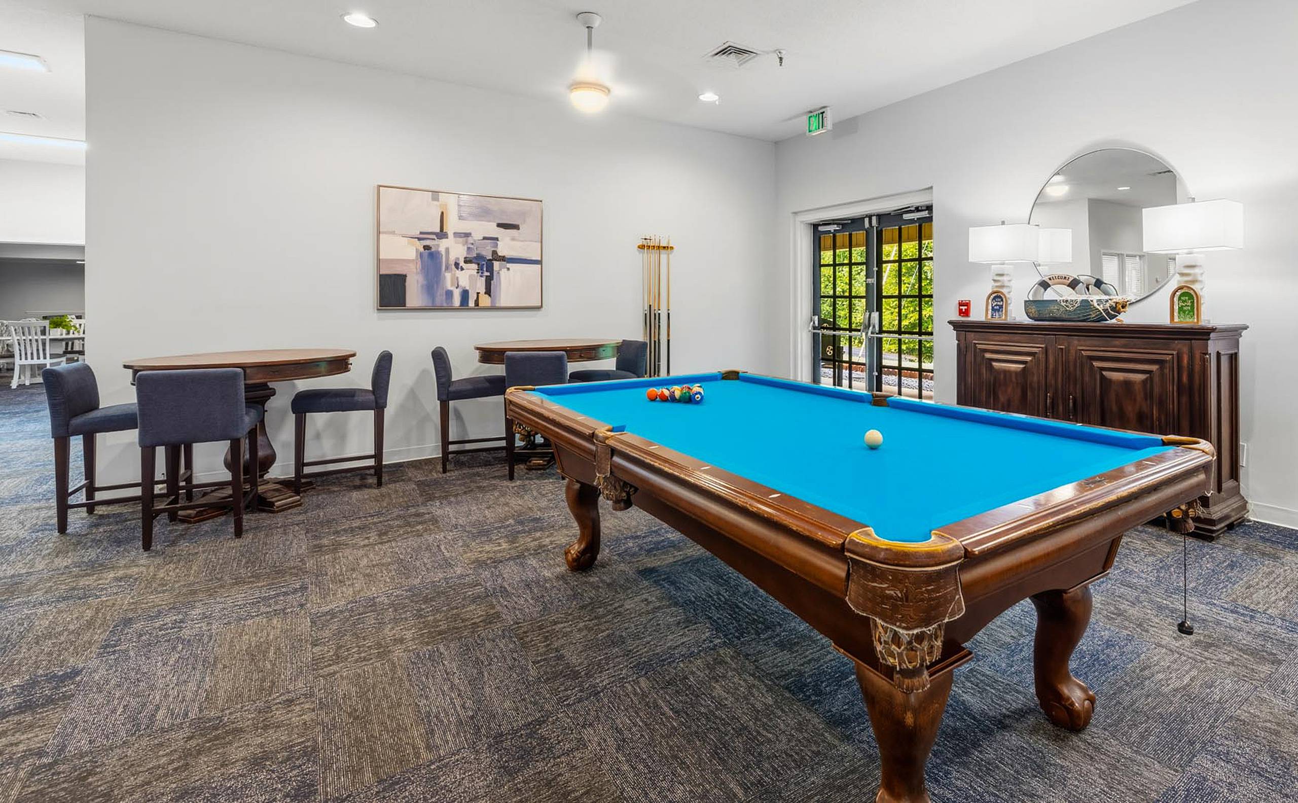Billiards room with pool table and pub-height tables at Serenity at Easley senior apartments