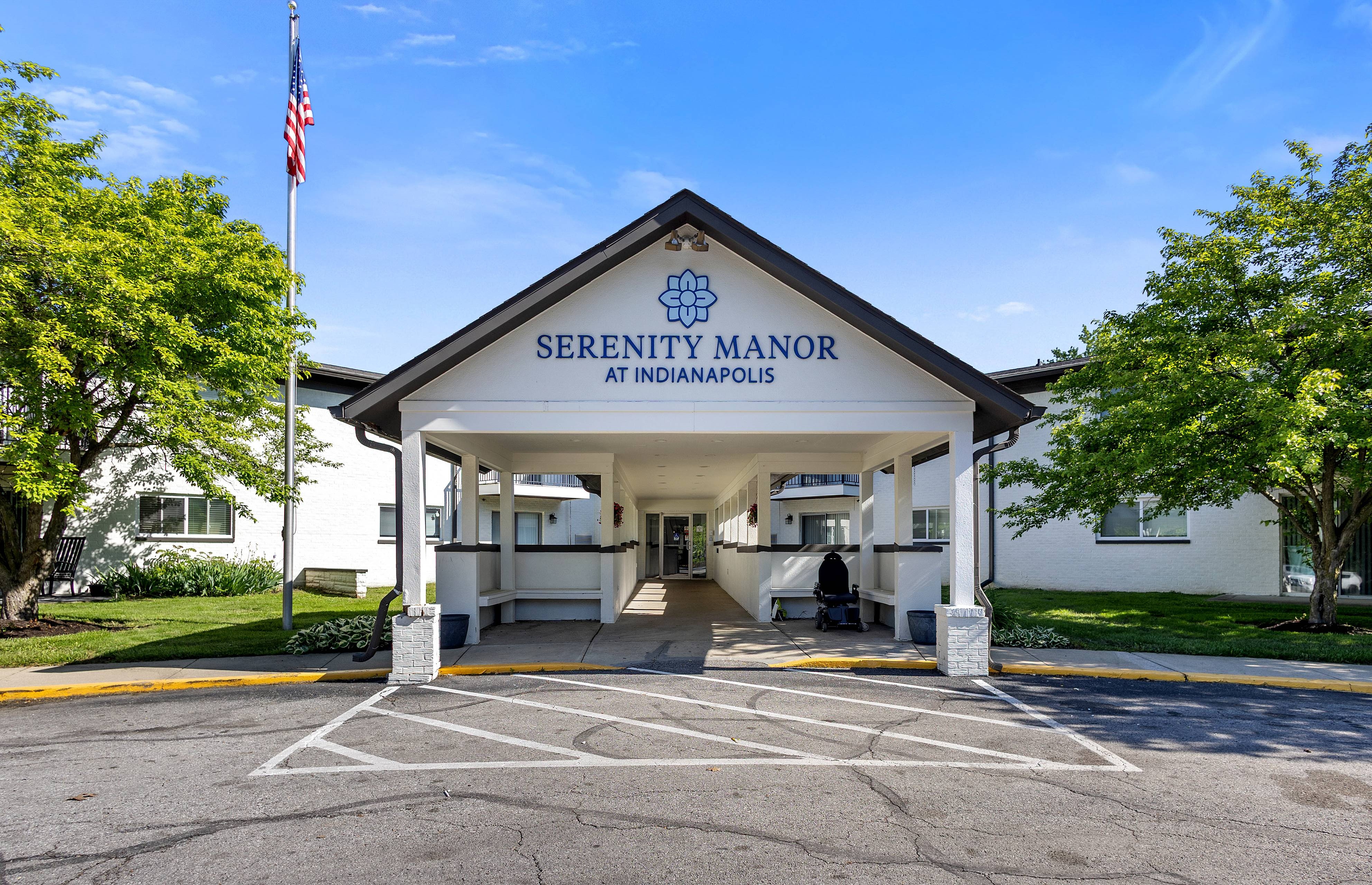 Serenity Manor at Indianapolis clubhouse entrance with gabled sign and flagpole in Indianapolis, Indiana
